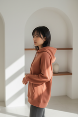Luxury pullover hoodie in Dusty Terracotta, side profile pose