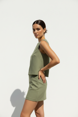 Women's co-ord skirt set in soft olive green, three-quarter turn pose
