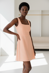 Luxury Square-Neck Mini Dress in Soft Peach - hand on hip pose