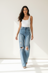 Premium distressed wide-leg denim pants in light wash blue - walking pose