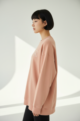 Luxury graphic sweatshirt in Washed Peach, side profile pose