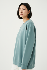 Luxury graphic sweatshirt in Dusty Aqua, three-quarter turn pose