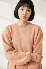 Luxury graphic sweatshirt in Washed Peach, detail close-up of graphic print and fleece texture