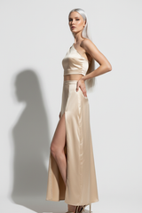 Women's satin slit skirt set in champagne gold, three-quarter turn pose