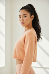 Luxury cropped sweatshirt in Soft Apricot, three-quarter turn pose