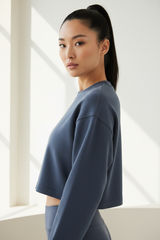 Luxury cropped sweatshirt in Deep Slate Blue, three-quarter turn pose